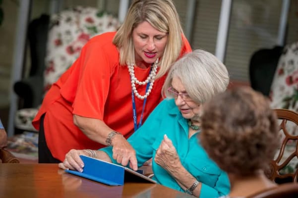 Staff assisting a resident with reading materials