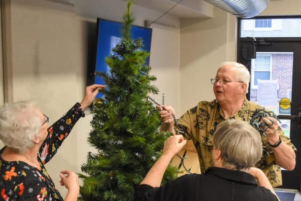 Residents decorating a Christmas tree together