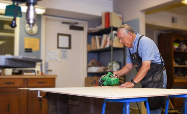 Senior man engaged in woodworking activity in a craft room