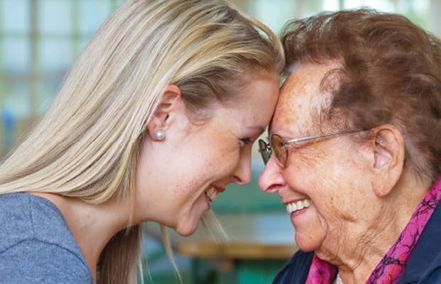 A caregiver sharing a joyful moment with a resident