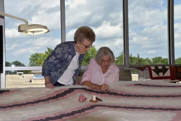 Two residents working on a quilting project together