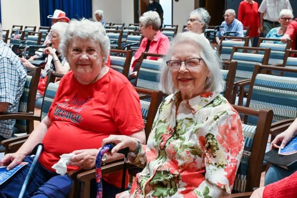 Two smiling residents in a community event setting