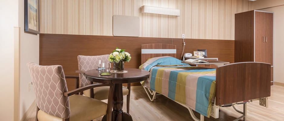 Cozy resident room with bed, table, and flowers