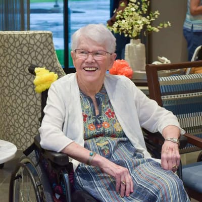 Smiling resident in a wheelchair in a common area
