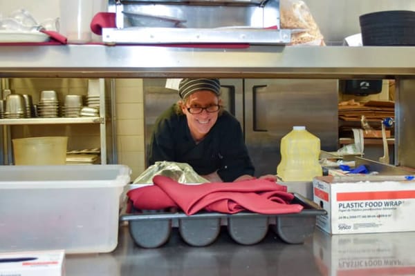 Staff member smiling in a kitchen setting