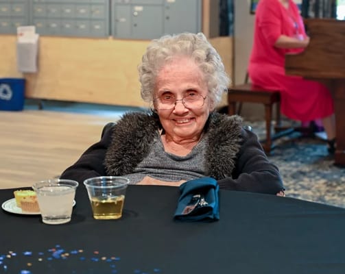 An elderly resident enjoying a dessert at a table