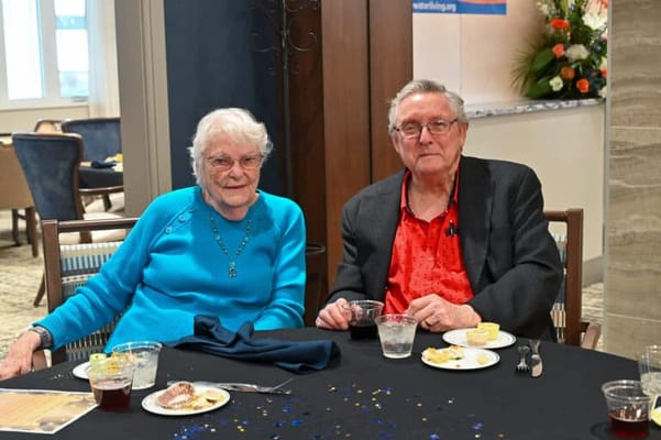Two residents enjoying dessert at a dining table