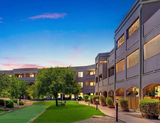 Exterior view of a senior living facility with a green lawn