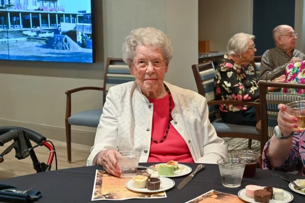 A senior woman enjoying dessert at a gathering