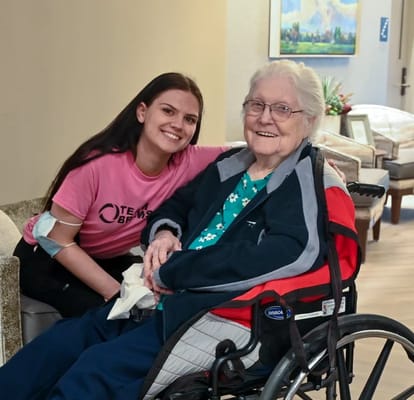 A smiling resident and staff member in a cozy interior