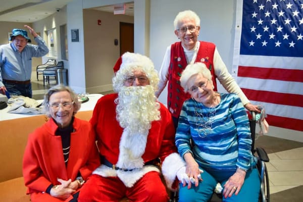 Residents celebrating with Santa in a common area