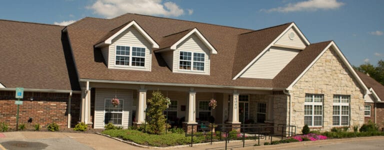 Exterior view of a senior living facility with gardens