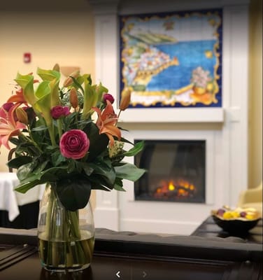 Vase with flowers in front of a colorful mural