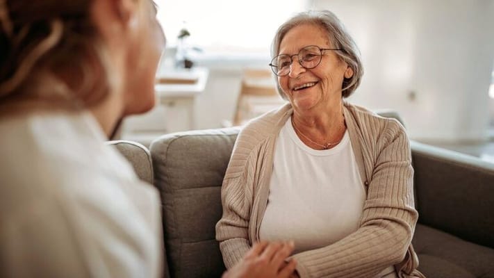 Smiling elderly woman interacting with caregiver