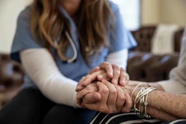 A caregiver holding a senior resident's hands