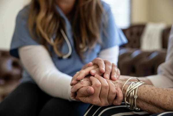 A caregiver holding a senior resident's hands