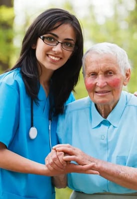 A caregiver smiling with a senior resident outdoors
