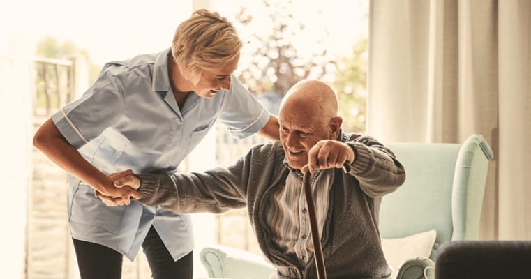 Healthcare worker assisting an elderly resident indoors