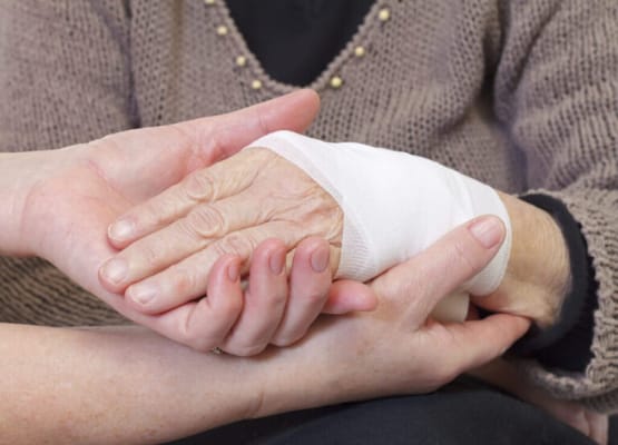 Close-up of caregiver holding a senior's hand