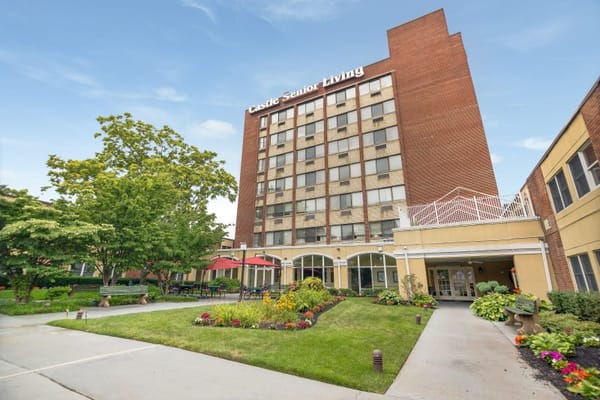 Front entrance of Castle Senior Living with landscaped garden