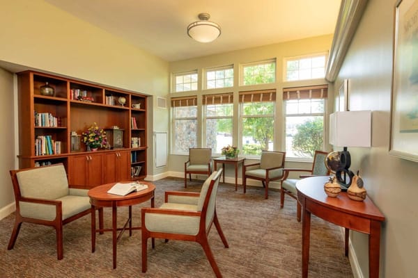 Warm interior seating area with bookshelves and windows