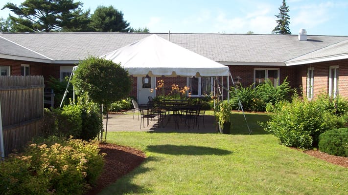 Outdoor seating area with a tent and greenery