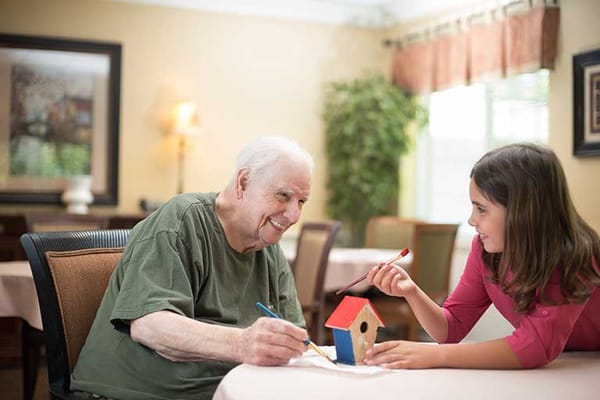A senior man and young girl engaged in an activity