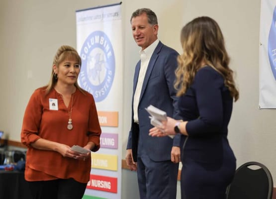 Two staff members engaged in conversation with a visitor