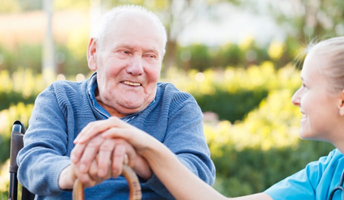Smiling resident with caregiver in a garden