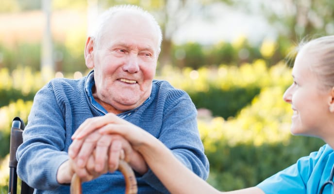 Smiling resident with caregiver in a garden