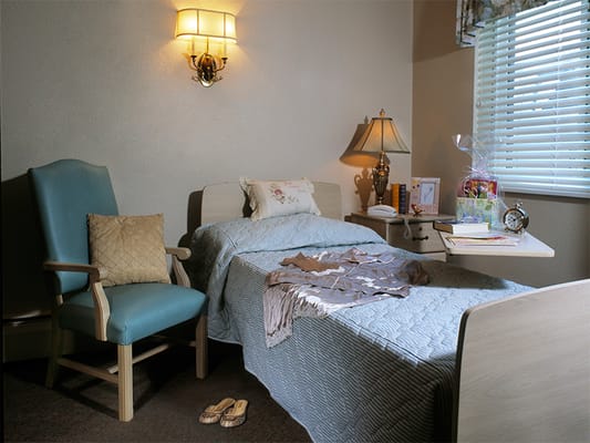 Cozy resident room with a chair and bedside decor