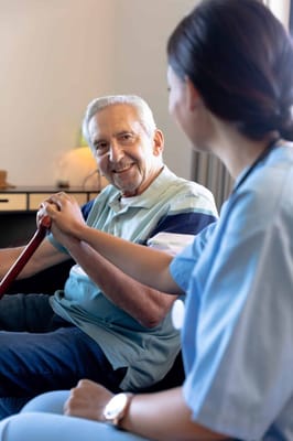 Staff engaging with a smiling resident in a cozy room