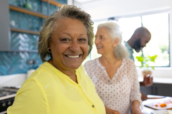 Residents smiling together in a kitchen setting