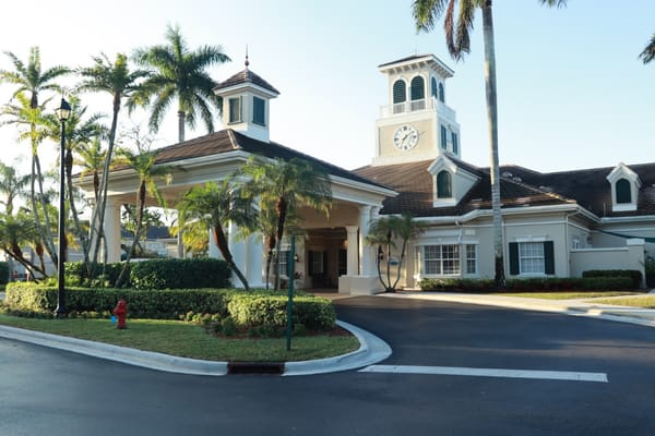 Exterior view of a senior living facility with tropical landscaping