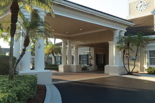 Entrance of a senior living facility with palm trees