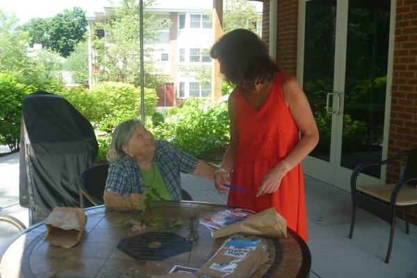 Resident engaged in an activity with staff member outdoors