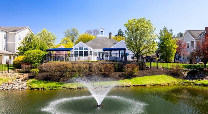 Exterior view of assisted living facility with a pond and fountain