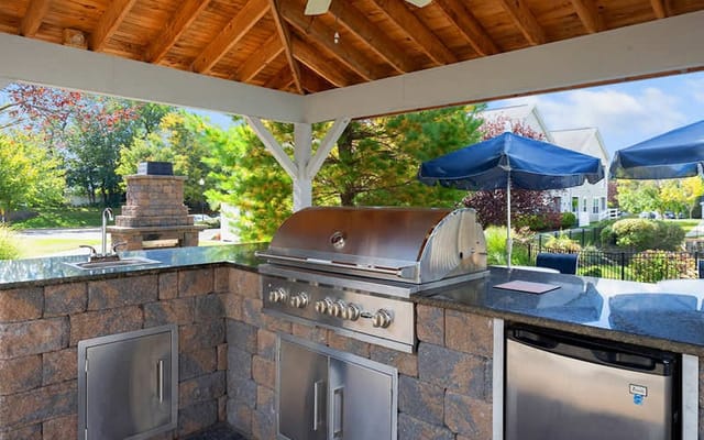 Outdoor grilling station with a stone bar and umbrellas