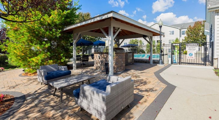 Outdoor seating area with pool in the background