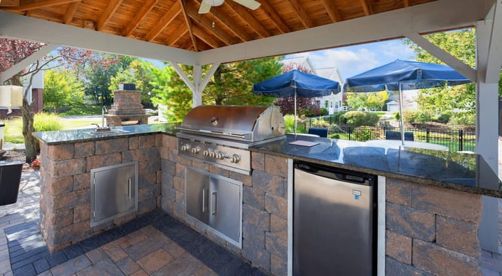 Outdoor grilling area with seating and umbrellas