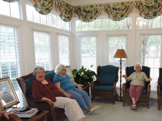 Residents laughing and relaxing in a sunlit common area