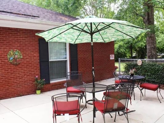 Outdoor seating area with green umbrella and chairs