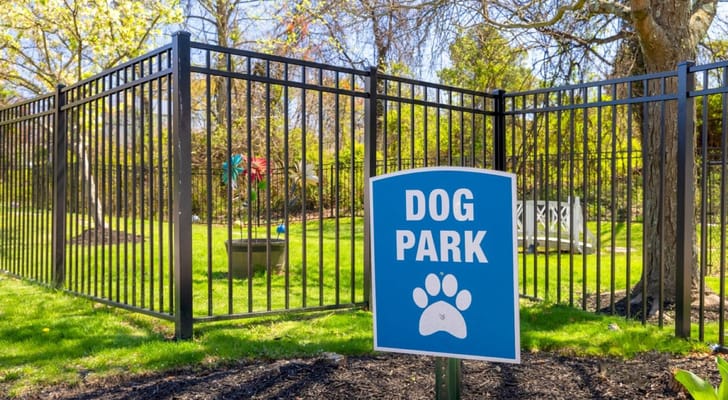 A fenced dog park with a sign indicating its purpose