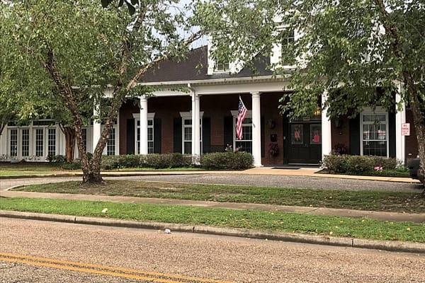Exterior view of Dauphin Way Senior Living with gardens