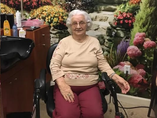 Resident enjoying salon services in a cozy interior setting.