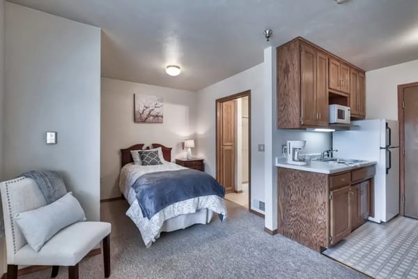 A cozy single resident room with a bed and kitchen