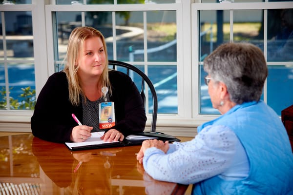 Staff member speaking with a resident in a sunny room