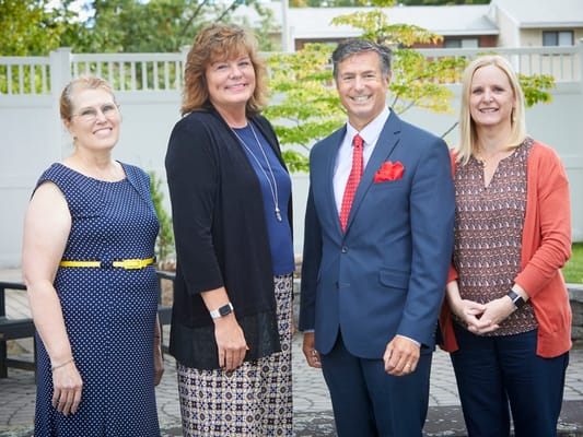 Four staff members in a courtyard of the facility
