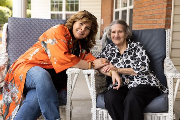 A staff member and resident enjoying time together on a porch