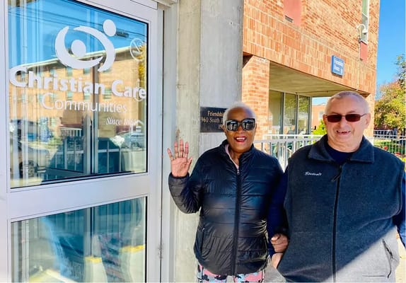 Residents waving outside the Christian Health Center entrance